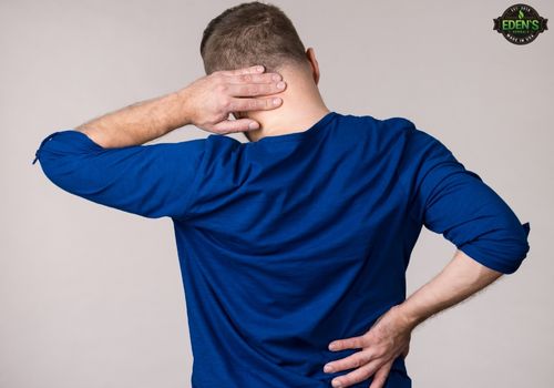 man holding neck and back to show where his muscle pain is irritating him